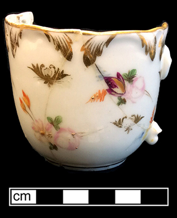 European hard paste porcelain, painted cup with molded leaf rim with gold gilt trim, gold gilt rim on interior, painted overglaze floral sprigs in pink, orange, blue, purple & yellow.